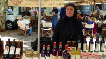 Nun selling wine at Wednesday Market in Uzes, Languedoc Roussillon, France