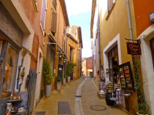 A Rousillon street full of the orche coloured buildings, from the local area